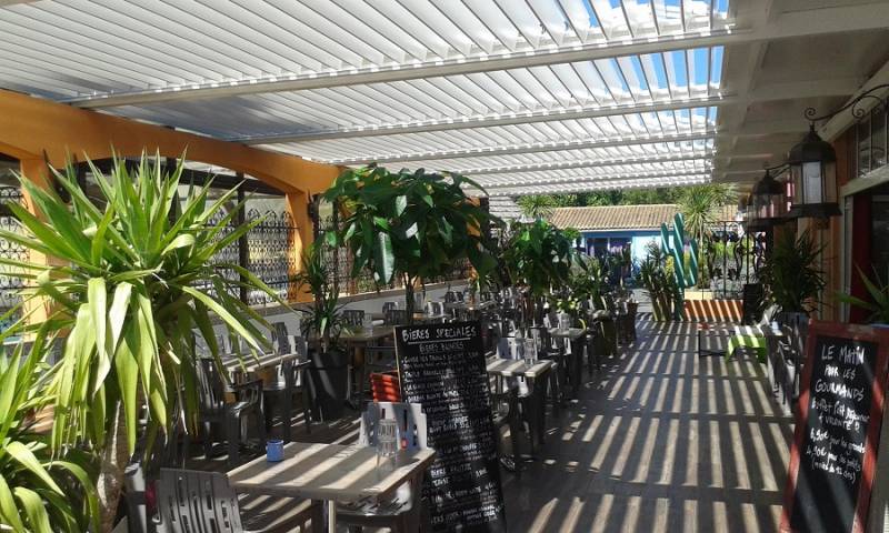 Pergola bioclimatique blanche adossée et sur-mesure pour terrasse de restaurant dans la région Rhône Alpes Auvergne