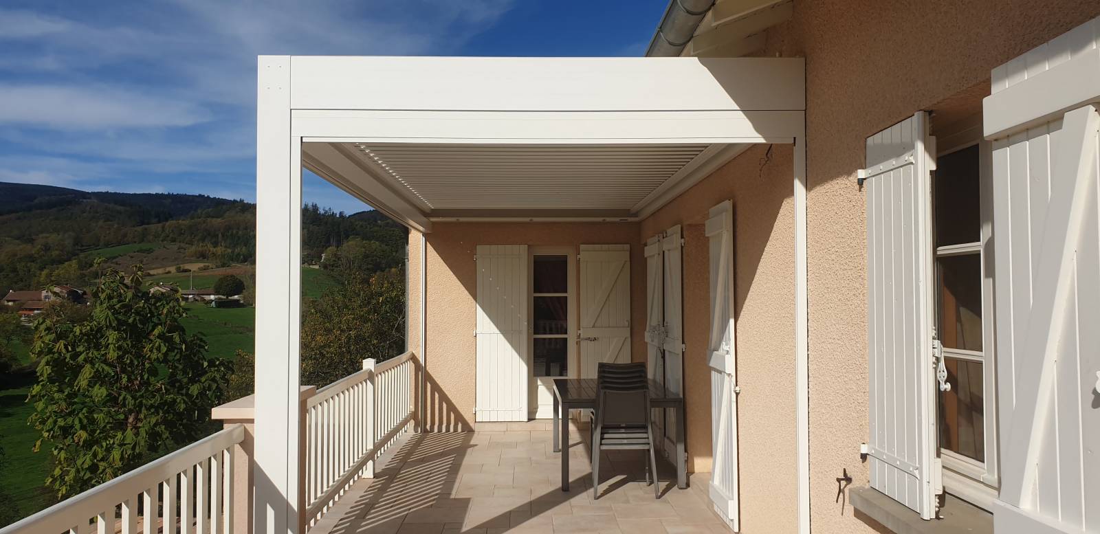 Pergola bioclimatique adossée , 6x3m, de couleur Blanche RAL 9010 avec stores motorisés et éclairage LED, à BEAUJEU (69)