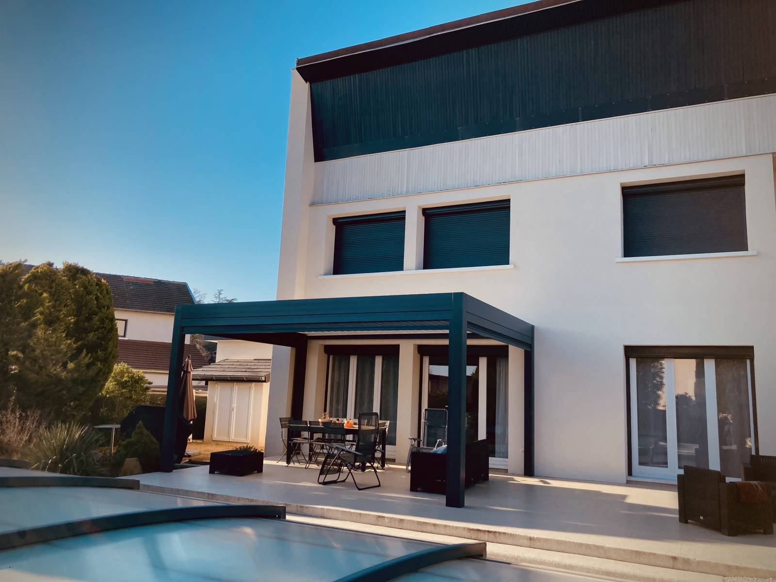 Pergola bioclimatique autoportée en aluminium coloris gris anthracite devant piscine dans le Rhône maison moderne