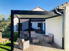 Pergola bioclimatique en aluminium sur mesure avec habillage latéral de brise soleil orientable et stores ZIP motorisés